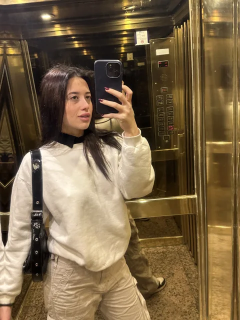 Natalye in a cream sweater and trousers